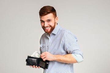 Finance, investment and money saving. Handsome man showing black wallet with dollars and smiling,...