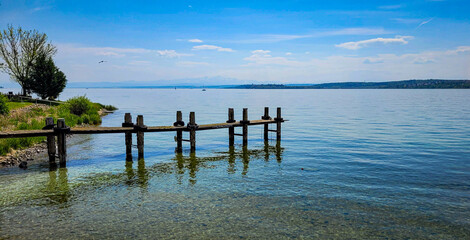 Beautiful view of lake Constance with transparent water and Swiss Alps on a sunny day