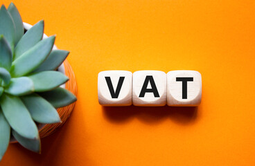 VAT - Value Added Tax symbol. Wooden cubes with word VAT. Beautiful orange background with succulent plant. Business and Value Added Tax concept. Copy space. - obrazy, fototapety, plakaty