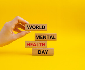 World Mental Health Day symbol. Wooden blocks with words World Mental Health Day. Businessman hand. Beautiful yellow background. Health concept. Copy space.