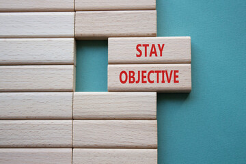 Stay Objective symbol. Wooden blocks with words Stay Objective. Beautiful green background....