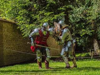 knights in steel armor fight with swords in the forest, metal armor shining in the sun, knight tournament
