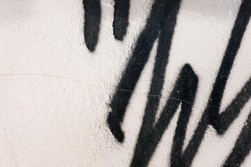 Abstract wall surface with part of graffiti. Black geometric lines on white wall background