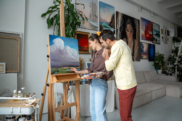 Creative woman painter drawing picture in art studio, husband enjoys process, good relationship....