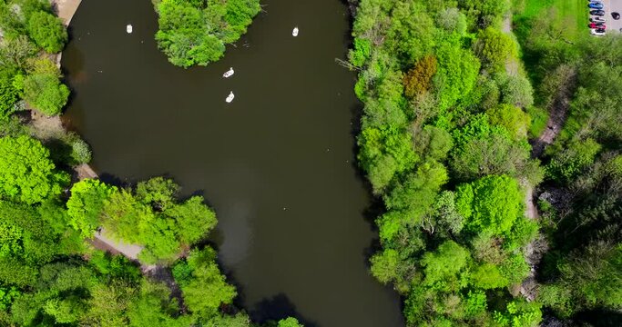 Birds eye view of boating lake in Heaton park Manchester showing people having fun with pedal boats 