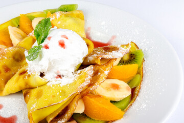 sweet pancakes filled with fruit and decorated with ice cream and mint leaf