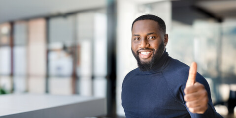 Successful man entrepreneur standing in modern office smiling