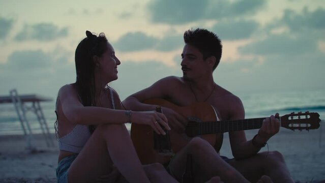 Guy playing guitar for his partner