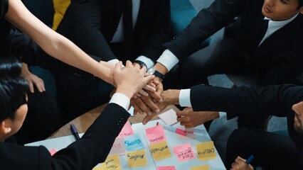 Top view of business people putting hands together and clapping hands to celebrate successful...