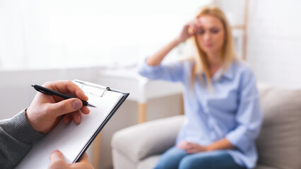 Depressed woman talking to psychotherapist, doctor taking notes about patient's health status, free...