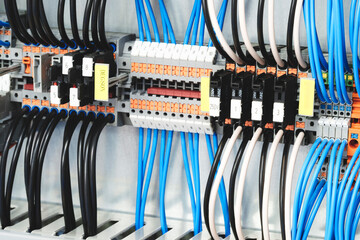 A bunch of wires are connected to a box with yellow and black labels