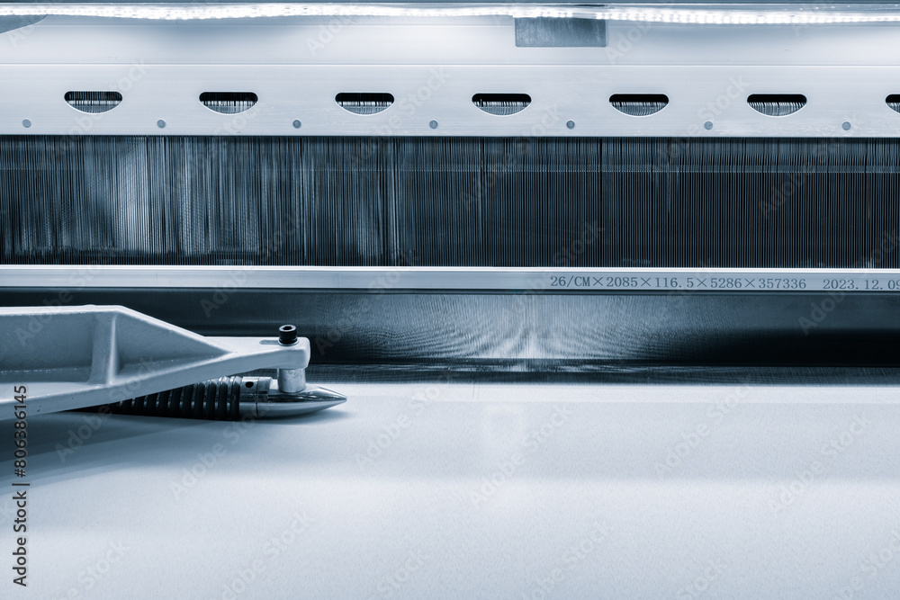 Leinwandbilder a machine is weaving a fabric with many different colored threads. the machine is blue and white