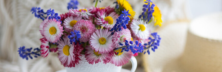 Banner. Flower arrangement with daisy and other summer flowers in a white cup. Spring floral composition. Greeting postcard for Mother's or Women's day, birthday, anniversary. Cozy atmosphere