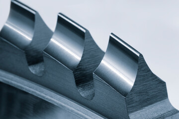 A close up of a metal piece with three ridges. The ridges are sharp and pointy, giving the piece a...