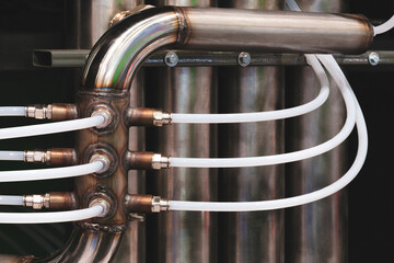 A pipe with four white tubes attached to it. Concept of complexity and organization, as the tubes...