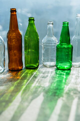 Empty bottles with creative shadows and fantastic highlights. Wastes of different glass containers ready for recycling. Separate collection of glass garbage. Eco friendly and zero waste concept