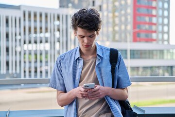 Relaxed handsome young male with smartphone, urban outdoor