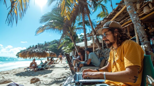 Man using laptop on a sunny tropical beach