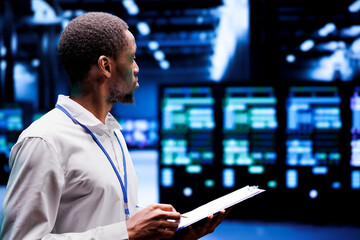 System admin checking energy efficient supercomputers hub using renewable sources to minimize...