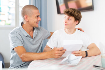 Obraz premium Happy son and father rejoice at the good news letter