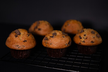 Homemade chocolate muffins on a black background. Selective focus.