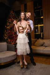 A happy family poses in pajamas in New Year's locations.