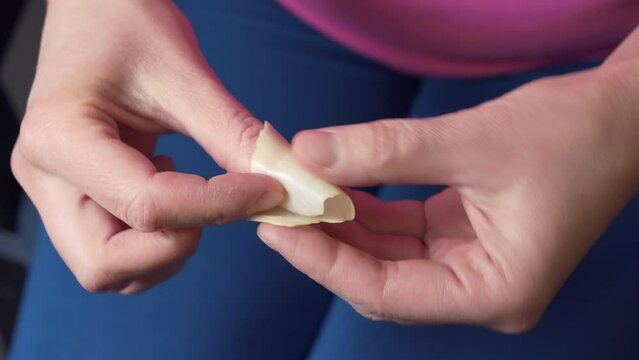 The woman is bandaging her finger with a cabbage leaf. Folk medicine. Close-up
