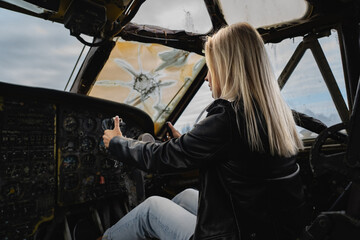 A blonde girl at the helm inside a military decommissioned An-12 cargo plane.
