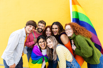 LGBT young group of people having fun with rainbow flag during gay pride day festival. LGBTI community concept.