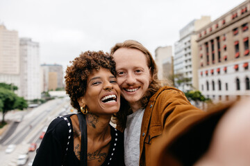 Joyful couple taking a selfie together on city streets