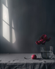 Peony in a glass and an apple on a gray tablecloth and a shadow on the wall.