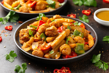 Irish spice bag take away food with potato fries, fried chicken, vegetables and curry sauce