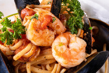 Close up of a plate of seafood pasta with mussels, shrimp and calamari in a tomato sauce