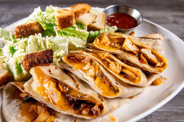 A Mexican Quesadilla cut into quarters and served with a green salad