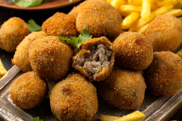 Fried Homemade beef Bitterballen with dijon mustard, ketchup and french fries