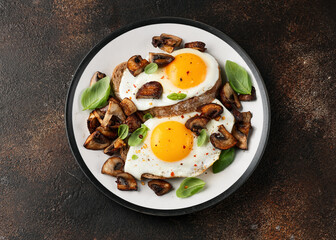 Mushrooms and fried eggs on toast with herbs breakfast