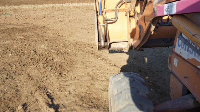side view pov on a backhoe bulldozer contruction machine, construction site dirt road