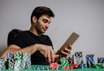 Side view handsome dark hair man, playing poker online on digital tablet