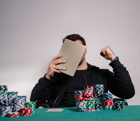 Unrecognizable man poker player, playing poker online on tablet and winning , tablet covering his...