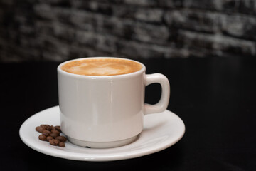 Cup of hot drink with steam over black background