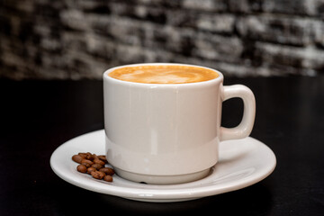 Cup of hot drink with steam over black background