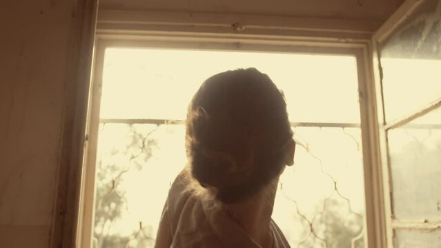 Woman does interpretive dance at a window