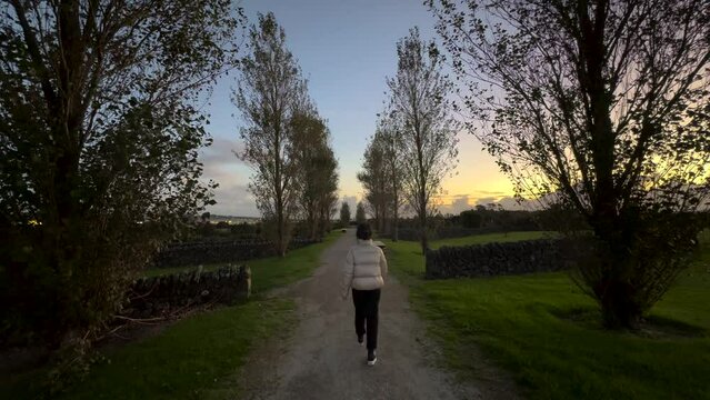 Asian woman walking in a park at sunset time in New Zealand