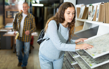 Woman chooses laminate flooring in hardware store