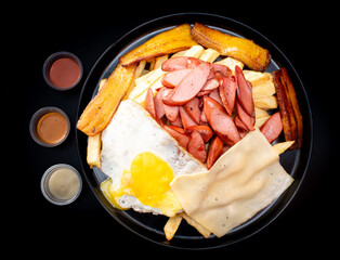 Salchipapa, peruvian grilled and sliced fresh pork sausage, potato fry on white background