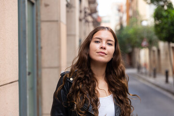 Fototapeta premium Cheerful female is walking in leather jacket on the street outdoor