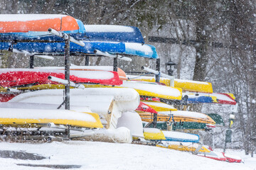 Colorful kayaks and canoes in snowstorm, New England coast