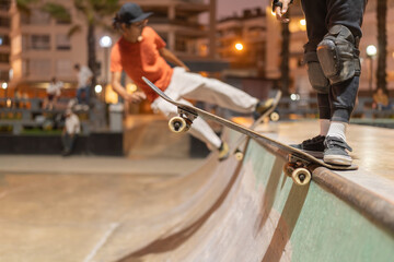 Kid skateboarding for jumping off the ramp with his coach next to him