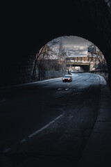 Car under dark bridge with tints of monochrome landscape