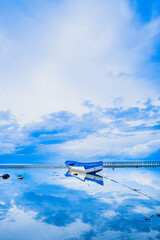 Boat on the beach cloudy blue sky background